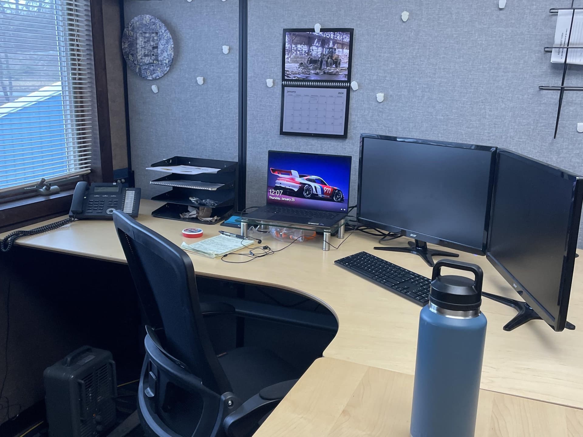 Inside this cubicle was my L-shaped office desk with a laptop and two monitors on it.
